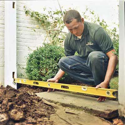 man with measurement tool near ground