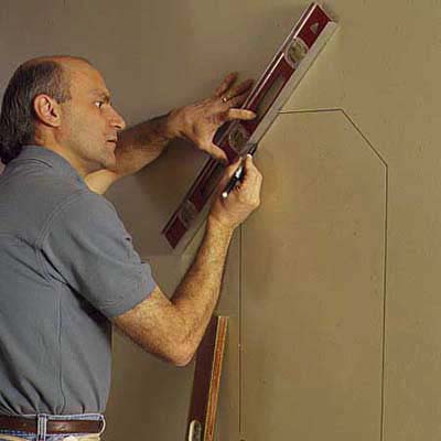 marking a wall to cut out drywall for niche installation