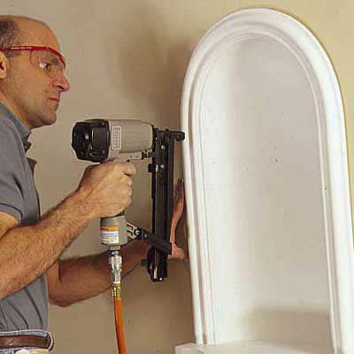 using a pneumatic nailer to nail the niche into place with minimal dings