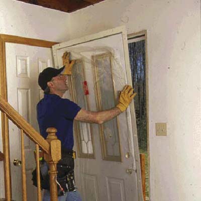 Set the bottom of the new prehung replacement door onto the sill and tilt it into the opening