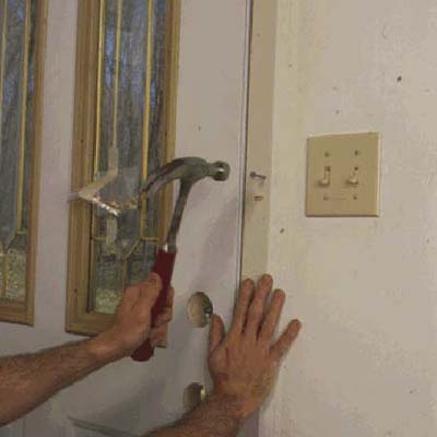 Temporarily secure the door by nailing through the predrilled holes in the steel frame and into the wall framing