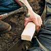 Tapping down the edging, using a hammer.
