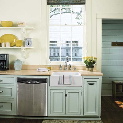 remodeled 1850s cottage kitchen with open shelves, off-white walls and pale green cabinets