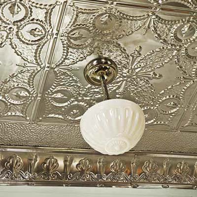 tin ceiling with a pendant light hanging from a medallion