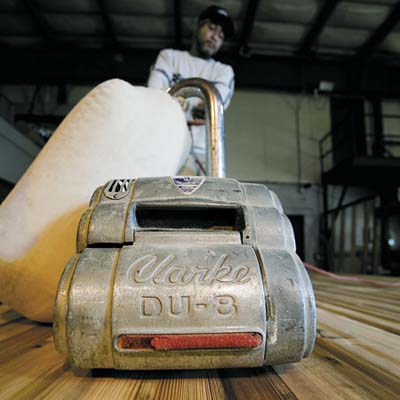  Jesse Hastings uses a large drum sander to smooth the Tiny Texas Chapel's tongue-and-groove floor