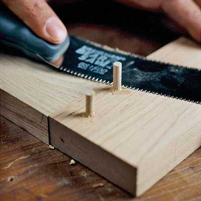 slicing birch pegs flush with the frame of the heirloom dresser