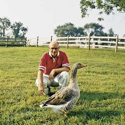man sitting in the yard with a duck