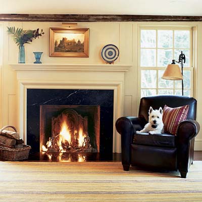 living room of rehabbed 1834 farmhouse with original timber beam and old firebox
