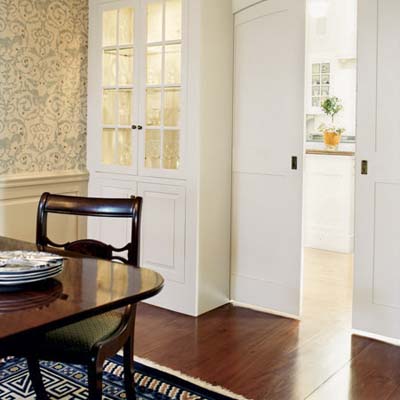 built-in cabinet and arched pocket doors in dining room of rehabbed 1834 farmhouse