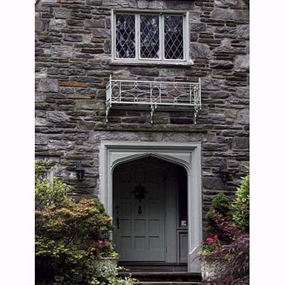a Tudor arch frames a recessed panel front door