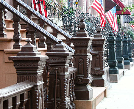 Cast-iron newel posts punctuate a lane of rowhouses.