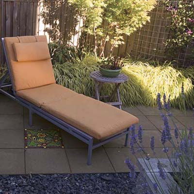 chaise lounge on a small patio with accent pavers