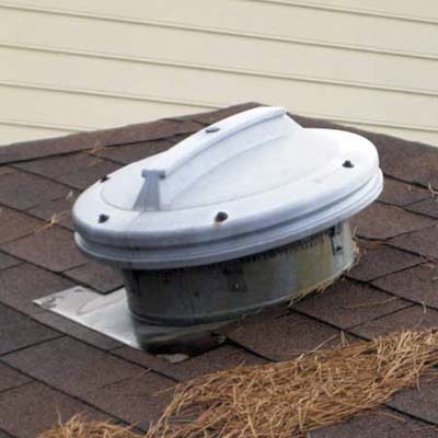 garbage can lid used as an external cover for an attic fan hood