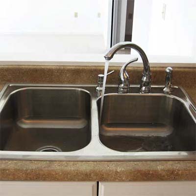 poorly installed sink faucet can't reach both bays of the double sink