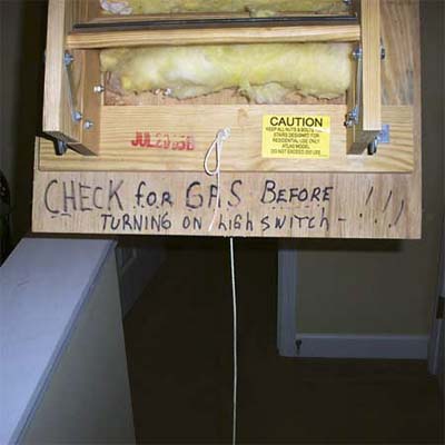 handwritten sign in a unlit attic asking people to not turn on the light for fear of a gas explosion