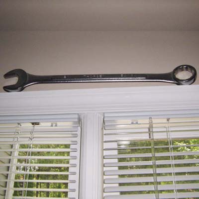 a 2-foot wrench located precariously above a window frame