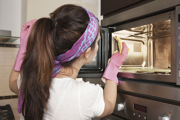 man leaned over looking deep into his microwave