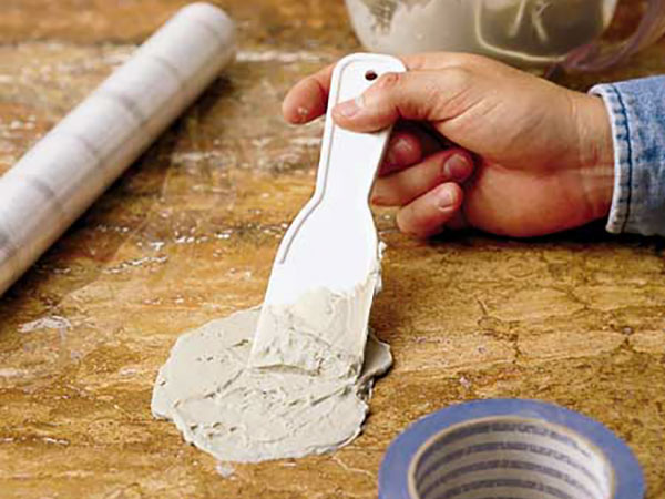 hand applying a fix mixture to a spill to keep it from staining