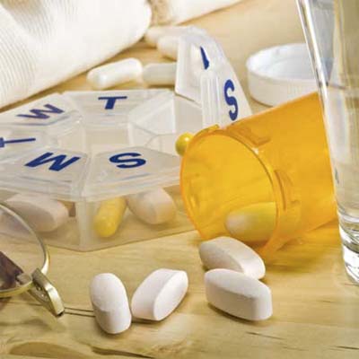 open pill bottle with pills spilled out over the counter