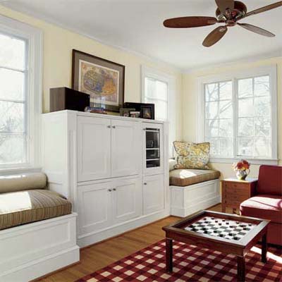 small benches built beneath windows on either side of a family entertainment system