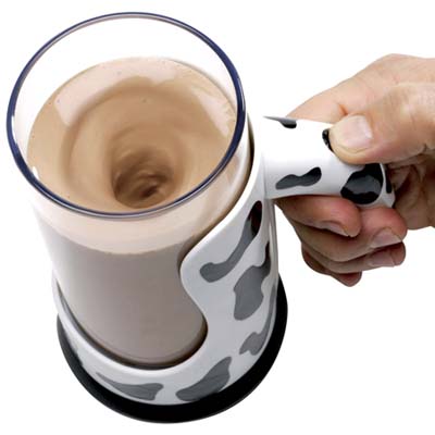 a push-button device that mixes chocolate milk in the plastic mug decorated with cow markings