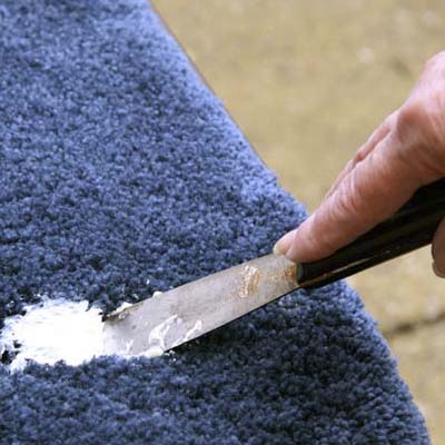 piece of carpet scrap used to wipe residue from a putty knife