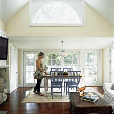 shed-roof dining area with mahogany floors and dramatic half-round window