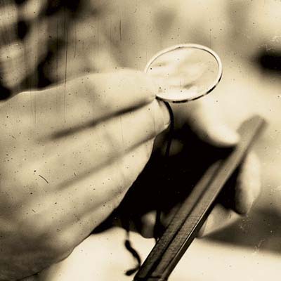 norm examining a folding ruler with a magnifying glass at the brimfield antique show in massachusetts