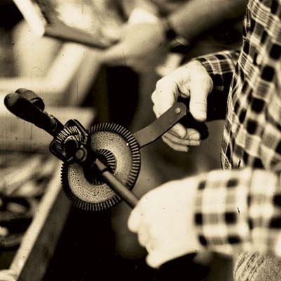 norm abram looking at a hand drill at the brimfield antique show in massachusetts
