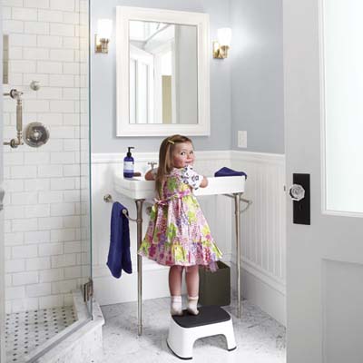little girl in front of console sink in remodeled bathroom