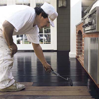 man staining deck with roller