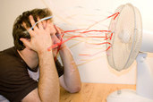 man cooling down in front of oscillating fan