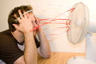 man cooling down in front of oscillating fan