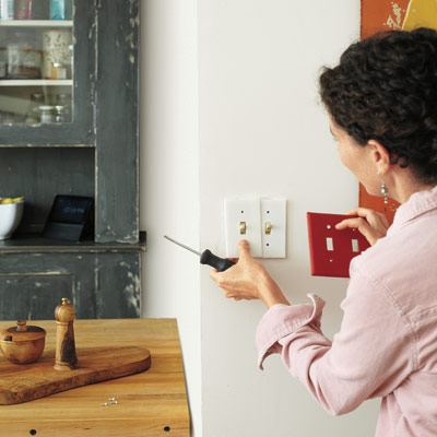 woman installing insulated light switch