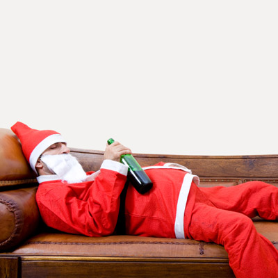 man in santa suit passed out with wine bottle