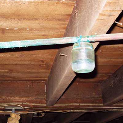 baby jar attached by wire to hang below a leaking pipe