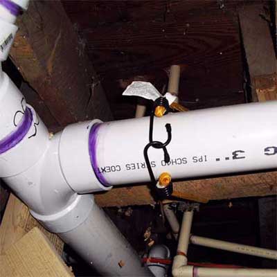 bungee cord holding up a three inch sewer line
