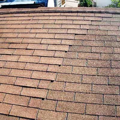 a new layer of shingles installed over an old layer that stops halfway across the roof