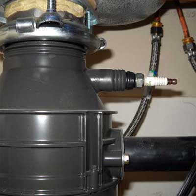 an old spark plug used to plug the opening in a sink disposal unit