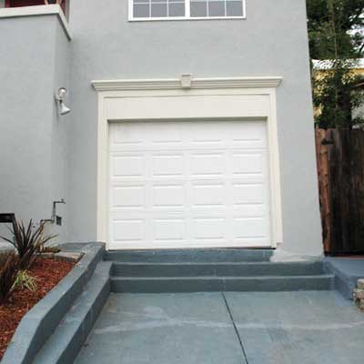 attached garage door installed at the top of three concrete steps built into the driveway