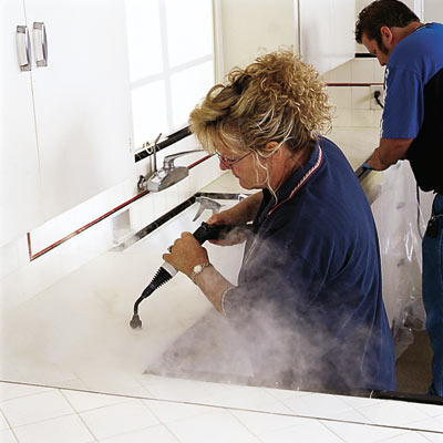 man and woman power cleaning tile grout
