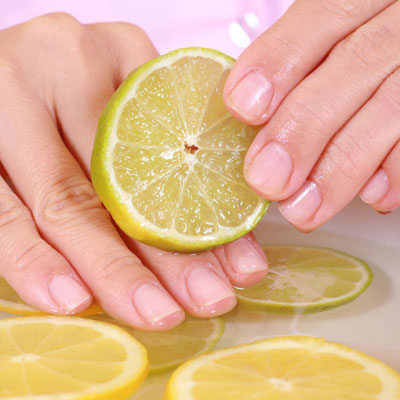 woman washing hands with lemon slices