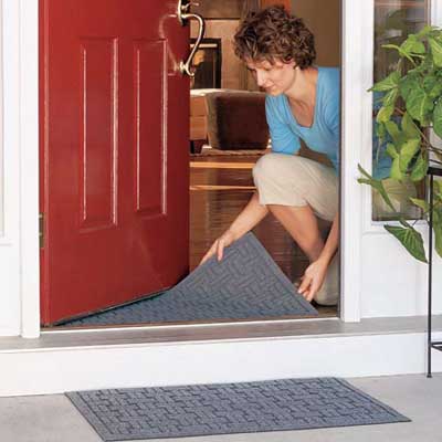 woman laying down door mats outside and inside an entryway