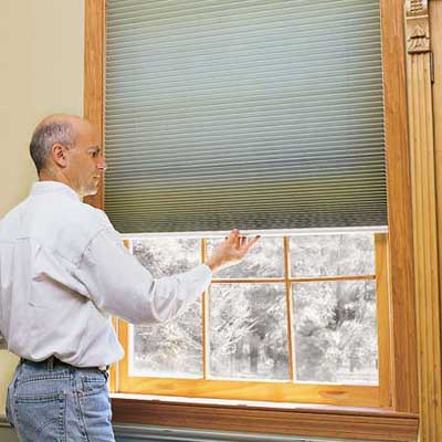 person lowering or raising some easy to clean blinds
