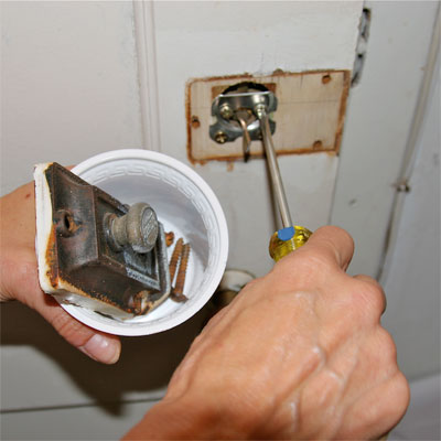 collection of hardware in a yogurt cup during a small repair