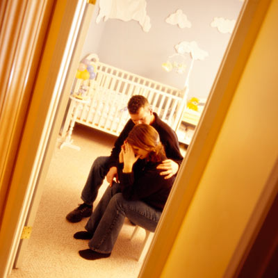 unhappy couple sitting in baby's room