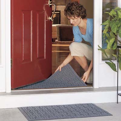 woman placing doormat on entryway floor