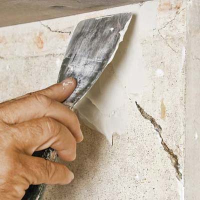 hands plastering cracked wall