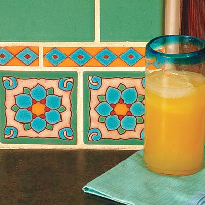 colorful hand glazed kitchen tiles and glass of orange juice