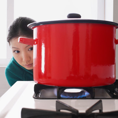 woman watching pot cook on stove top